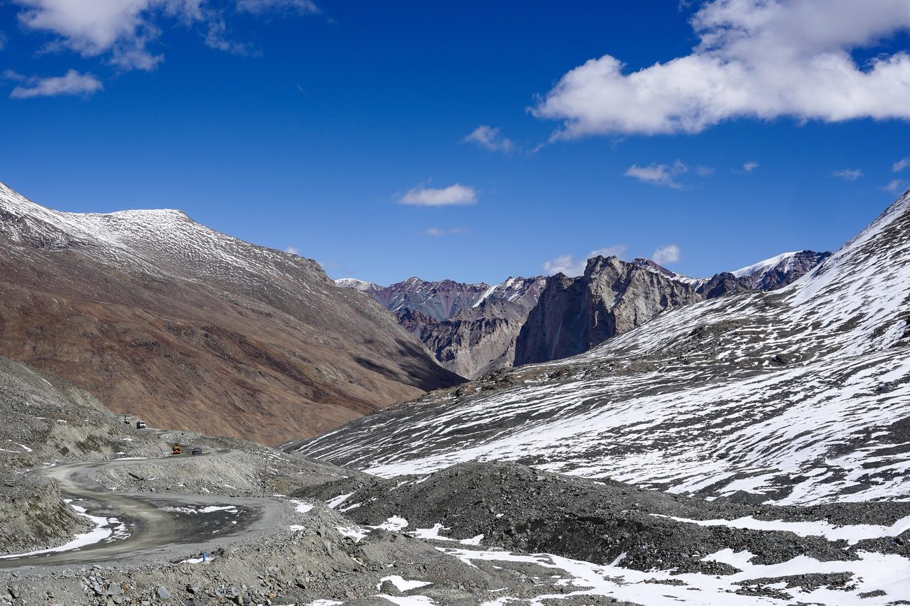 A road climbing to a snowy pass in Zanskar, Ladakh